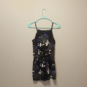 A black romper with purple and white floral print